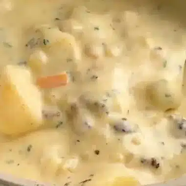 Bowl of legendary sausage potato soup garnished with herbs